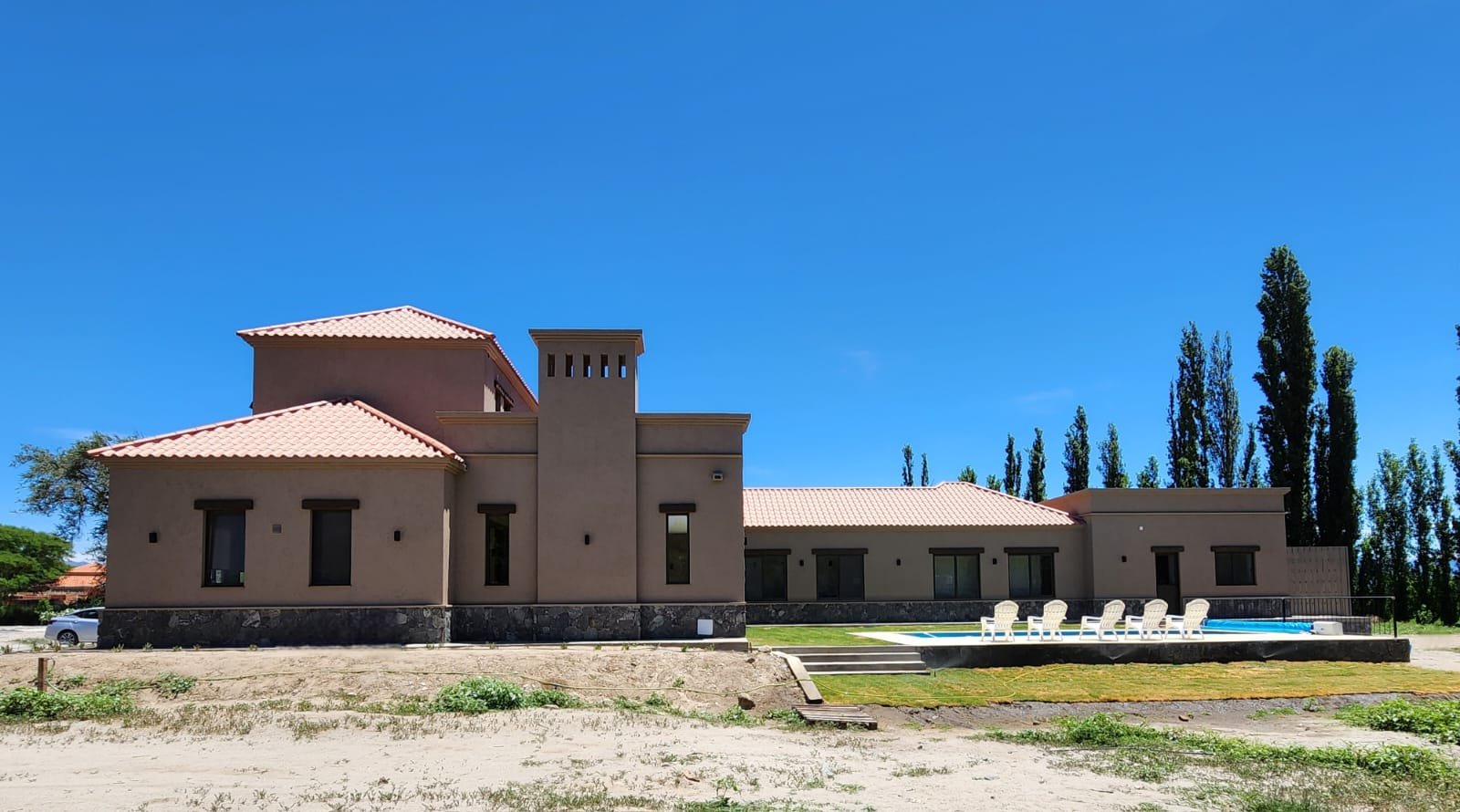 Fachada de casa moderna estilo mediterráneo con piscina — proyecto Ca La Estancia, por Luciana González Anderson, en Cafayate